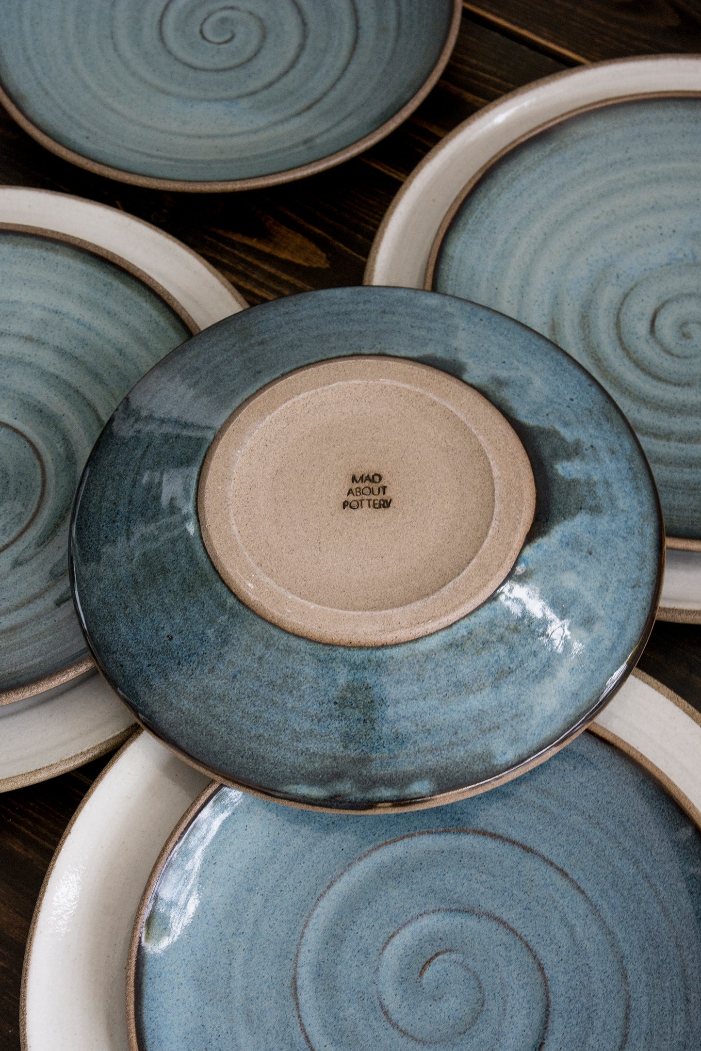 Stack of ceramic plates with swirling patterns and a visible brand name.