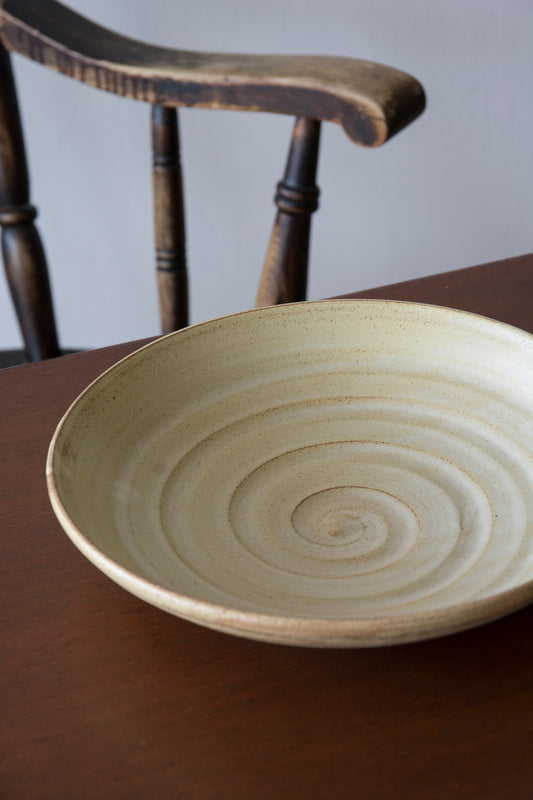 Detail of straw yellow matte glaze on grey speckled stoneware pottery