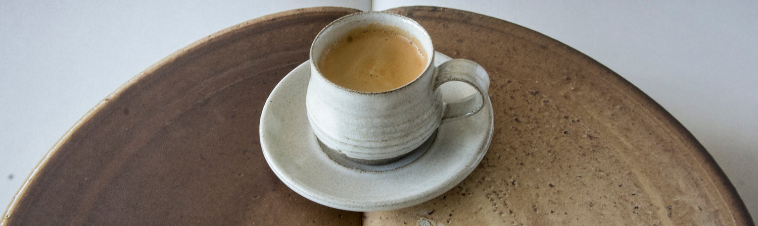 white espresso cup with saucer on a image of a book