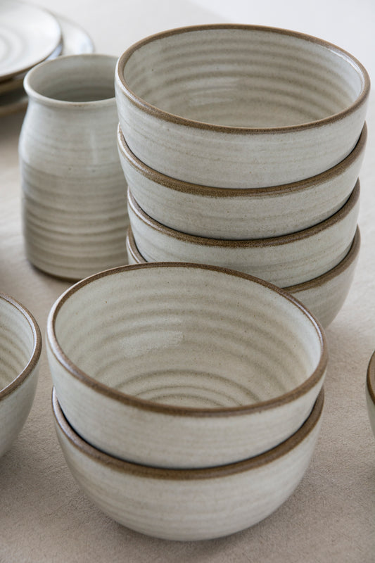 Minimalist ceramic serving bowl with earthy tones and a rustic unglazed rim detail.
