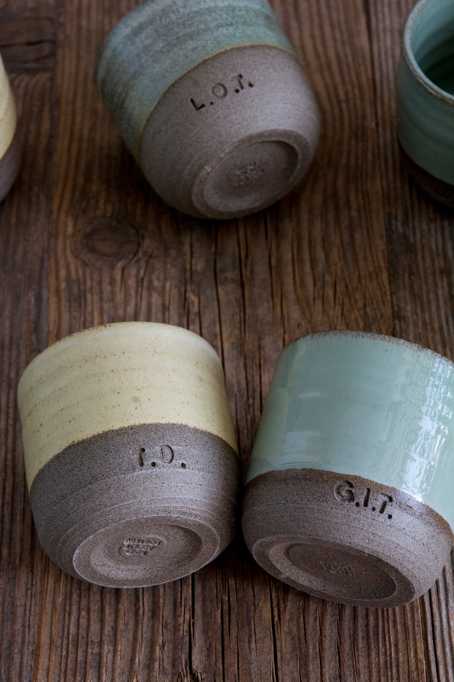 Three ceramic containers with text on a wooden surface