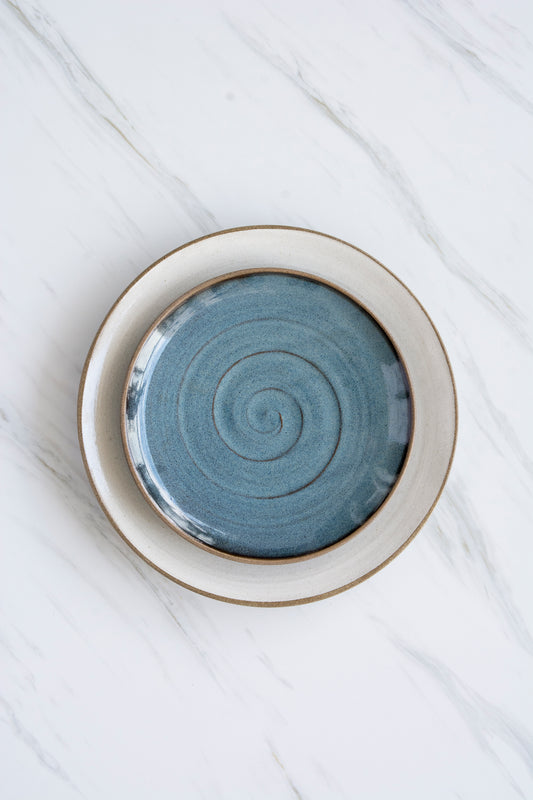 Ceramic plate with a spiral design on a white surface