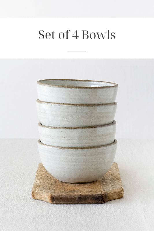 set of 4 white pottery handmade bowls on a white table